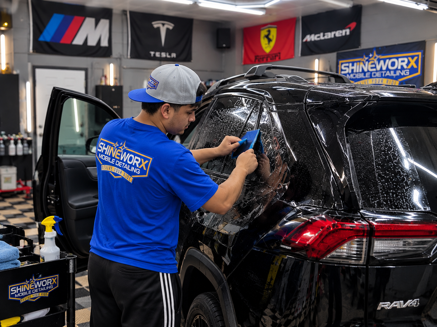 Shineworx technician installing window tint on a black Toyota RAV4